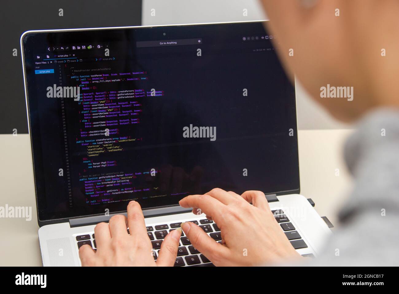 Un programador que codifica en un portátil en el lugar de trabajo Foto de stock