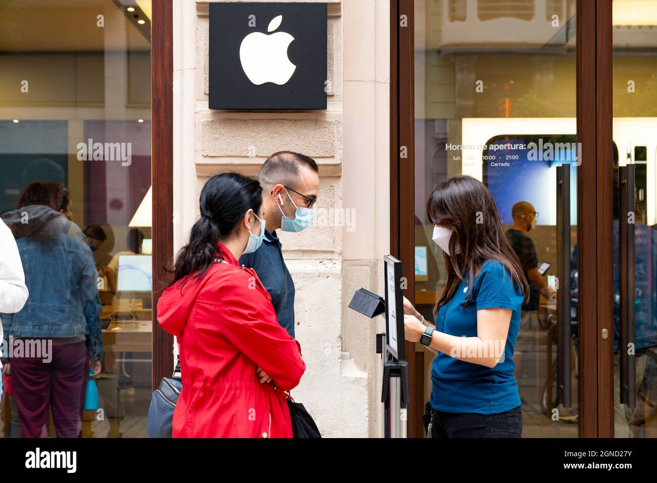 Valencia, España. 24th de Sep de 2021. Un trabajador de Apple vio a un  cliente en la puerta de la tienda Apple durante el primer día de venta del  móvil iPhone 13