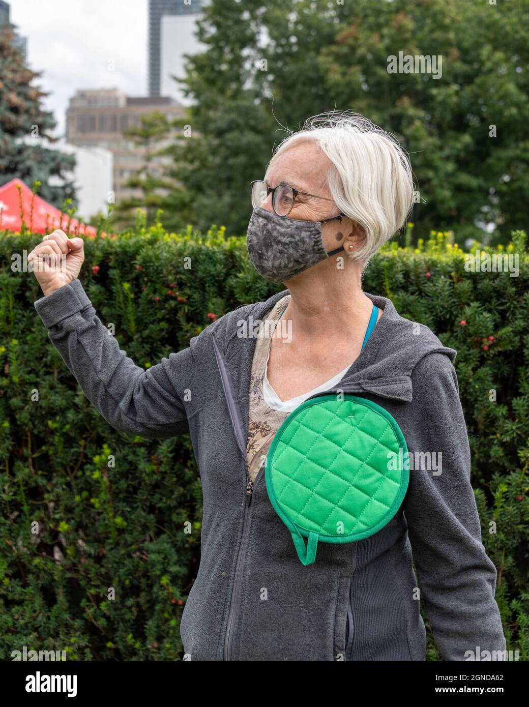 Mujer mayor con un paño de cocina verde como botón durante la Marcha Global del Clima organizada los viernes para el futuro en frente de la Provincia Foto de stock