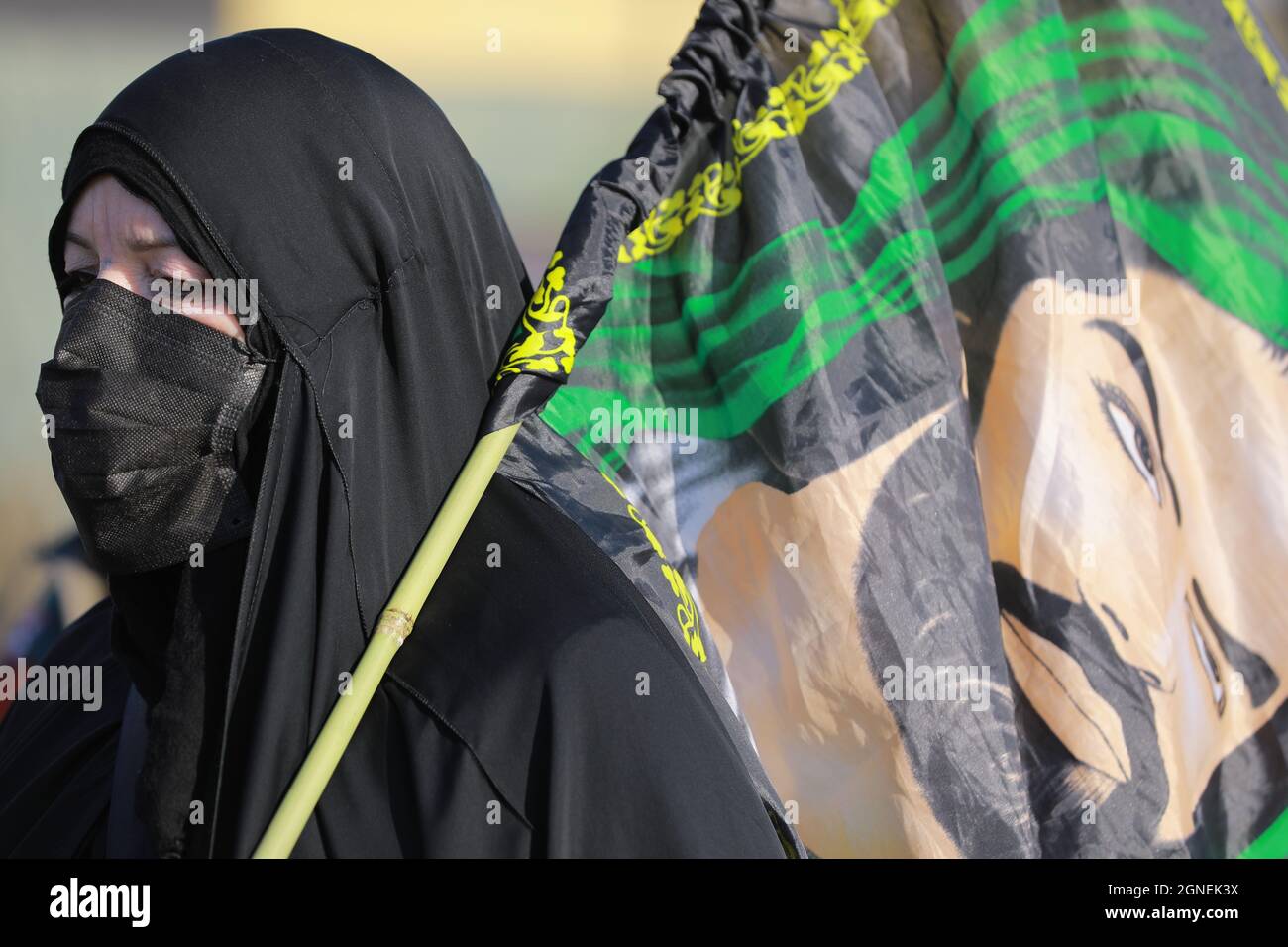 Bagdad, Iraq. 25th de Sep de 2021. Una mujer que lleva una bandera se  marcha con musulmanes chiítas de Bagdad para visitar la mezquita Husayn en  Karbala con motivo de Arba'een, también