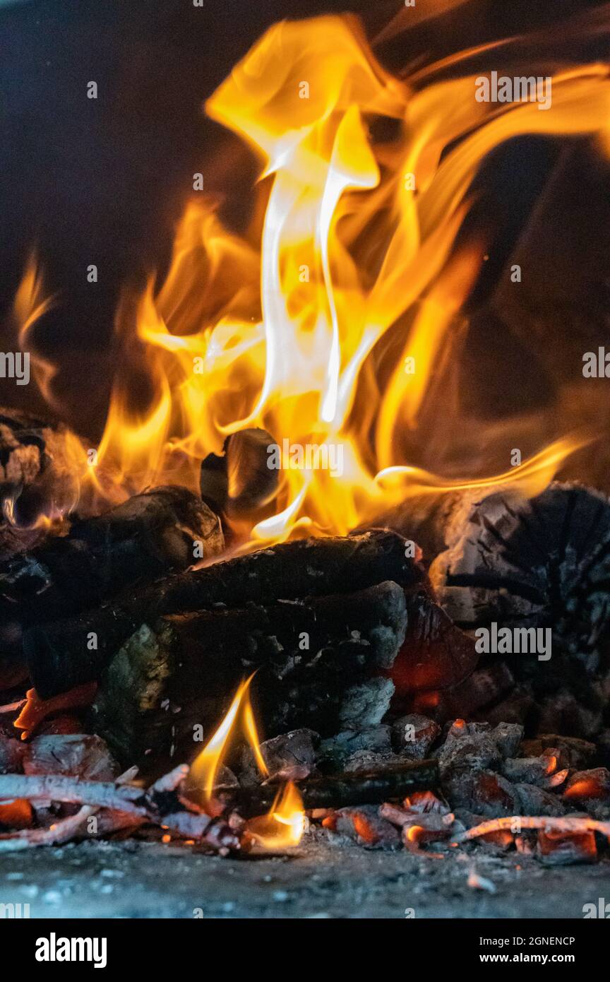 Llamas rojas, naranjas y amarillas de leña en un horno Fotografía de stock  - Alamy