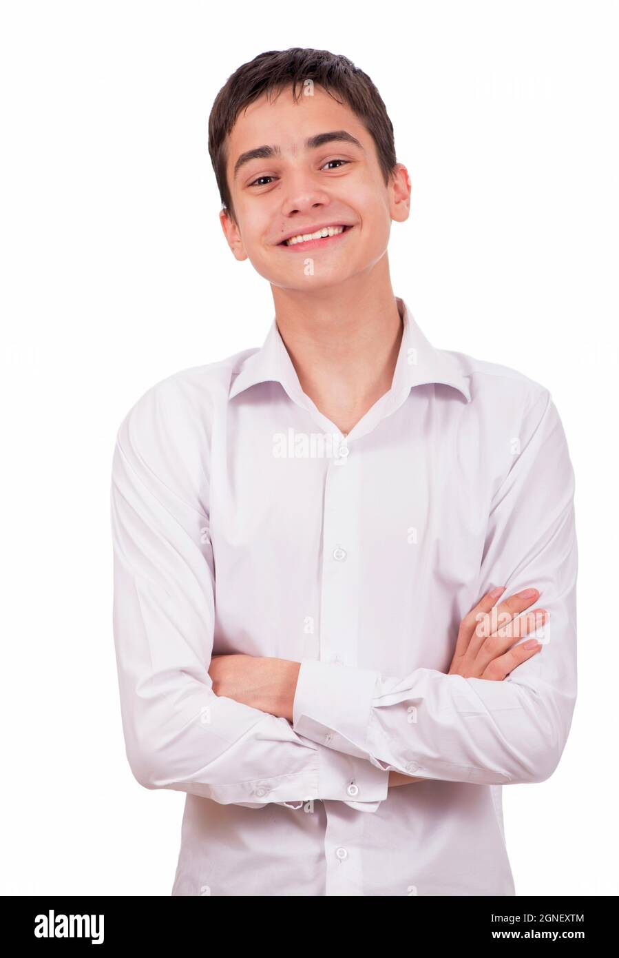 Retrato de feliz sonriente joven hombre vestido con una camisa blanca de pie con las manos plegadas contra aislado en blanco Foto de stock