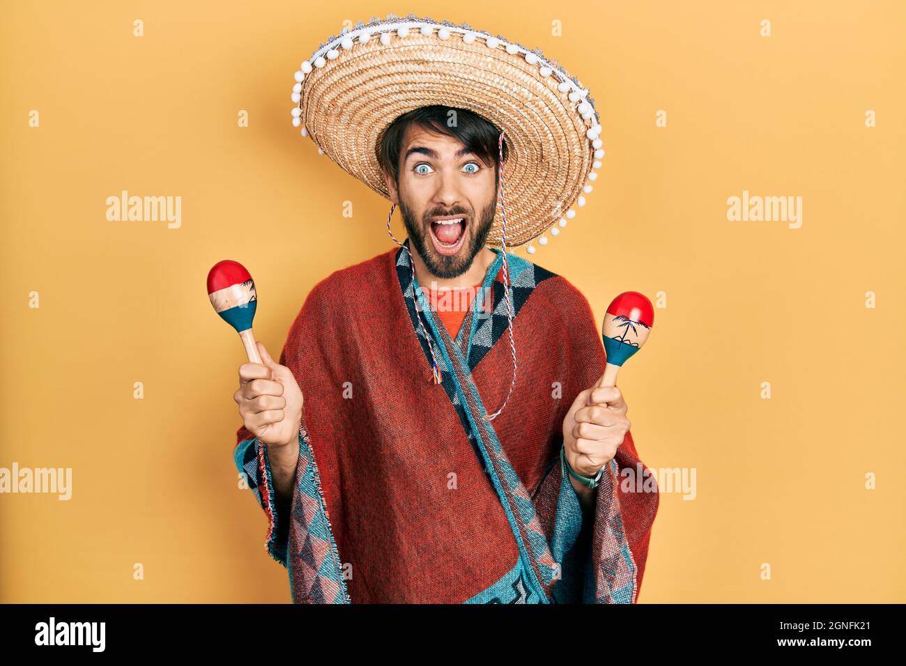 Joven hispano vestido con sombrero mexicano sosteniendo maracas celebrando  loca y asombrado por el éxito con los ojos abiertos gritando emocionado  Fotografía de stock - Alamy