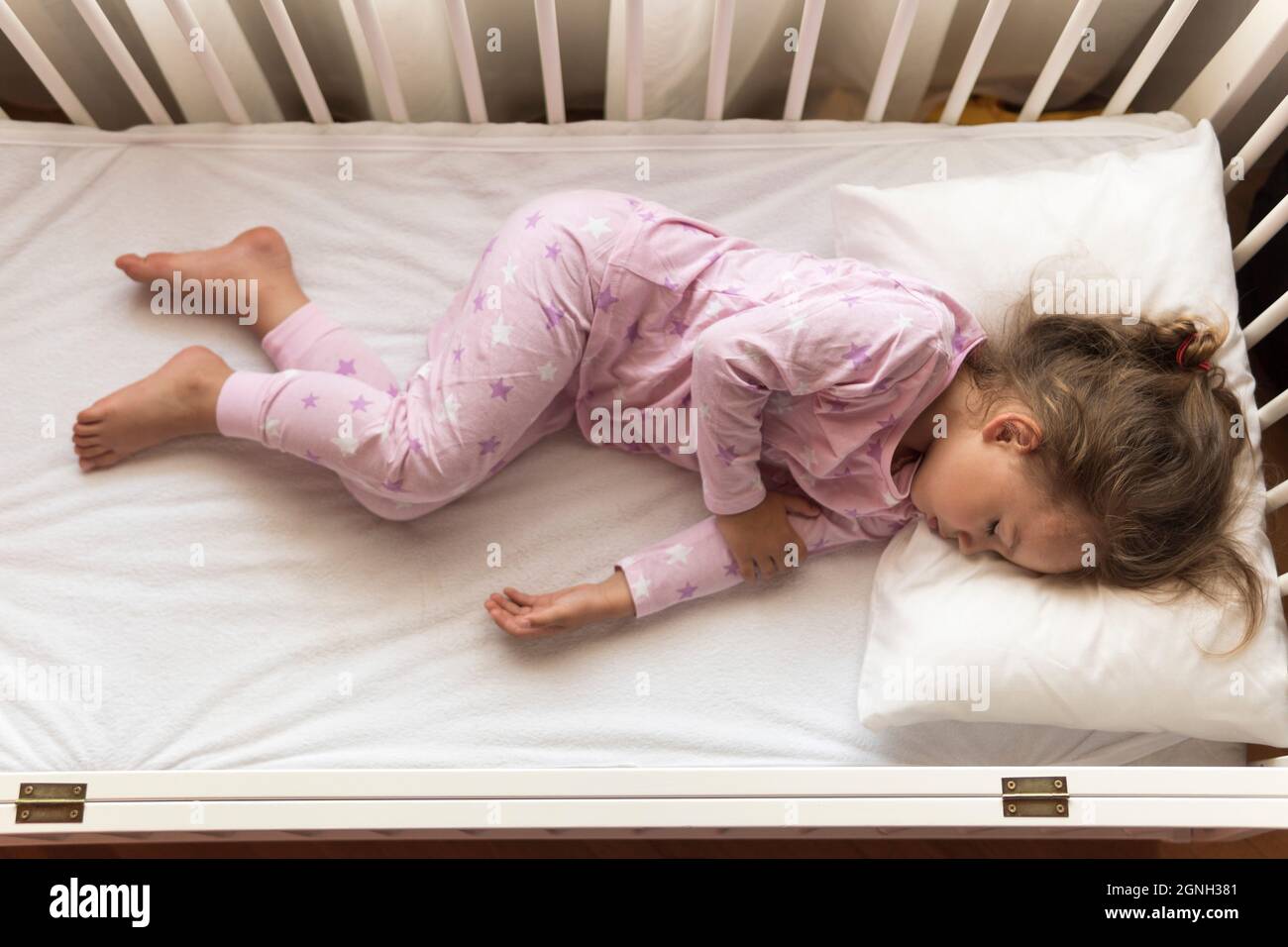 Vista superior Cute Little 3-4 años preescolar niña niño durmiendo dulcemente en cuna blanca durante el almuerzo tiempo de descanso en pijama rosa con almohada en casa Fotografía de stock - Alamy