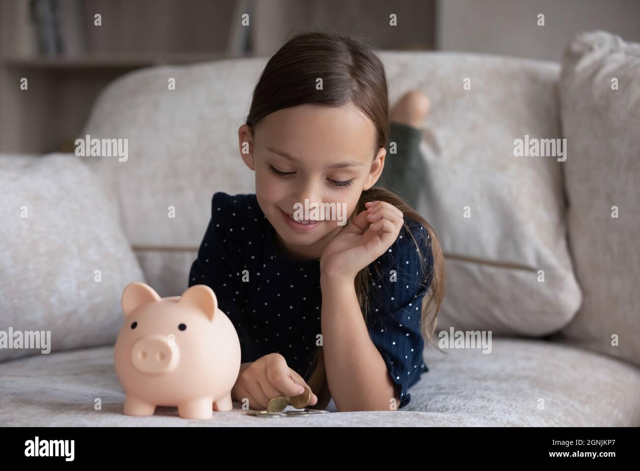 Sonriente adorable niña pequeña 7s años aprendiendo el presupuesto de planificación. Foto de stock