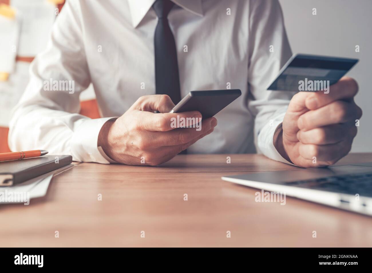 Banca móvil, hombre de negocios con teléfono inteligente y tarjeta de crédito para transacciones financieras en línea, de cerca con enfoque selectivo Foto de stock