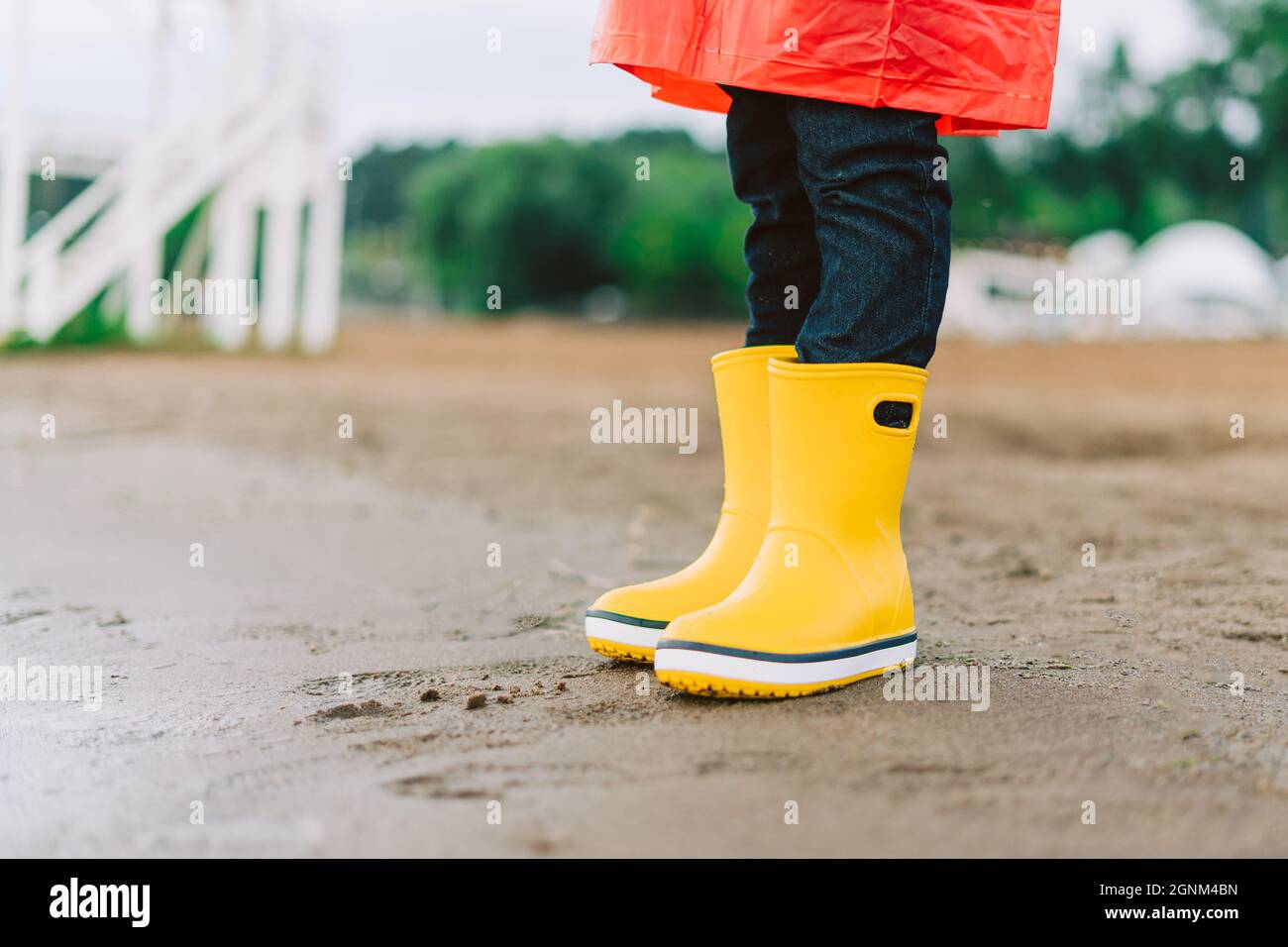 Humildad incompleto Nube Niño escolar con botas de agua amarillas en la playa. Niño de pie en la  arena con botas de goma impermeables Fotografía de stock - Alamy
