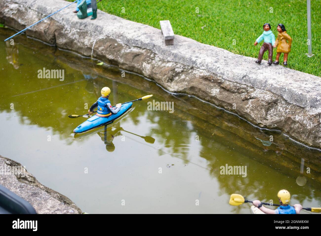 Primer plano de una pequeña persona modelo en un kayak en un río Foto de stock