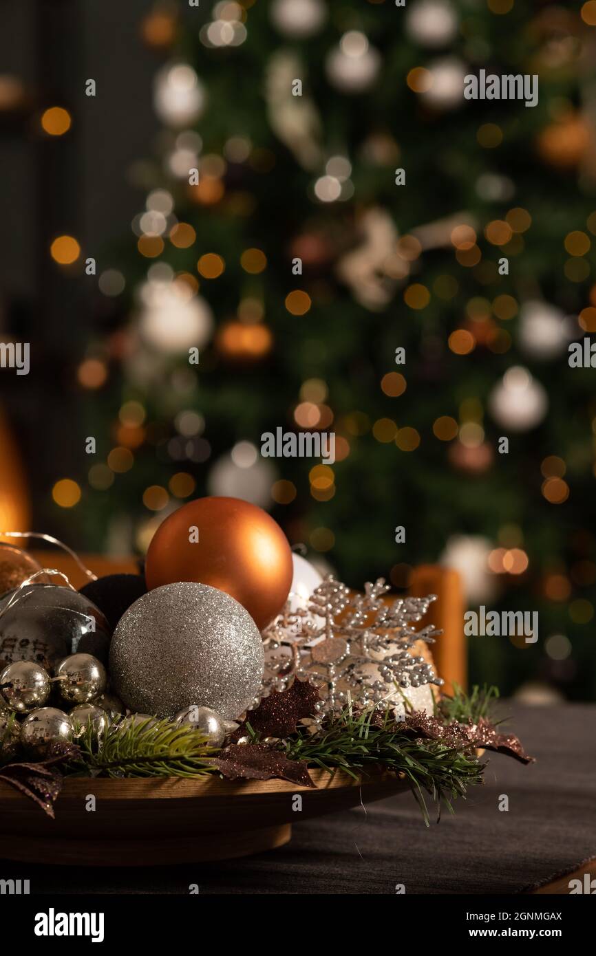 Bolas de Navidad sobre una mesa decorada en el fondo de un árbol de Navidad Foto de stock