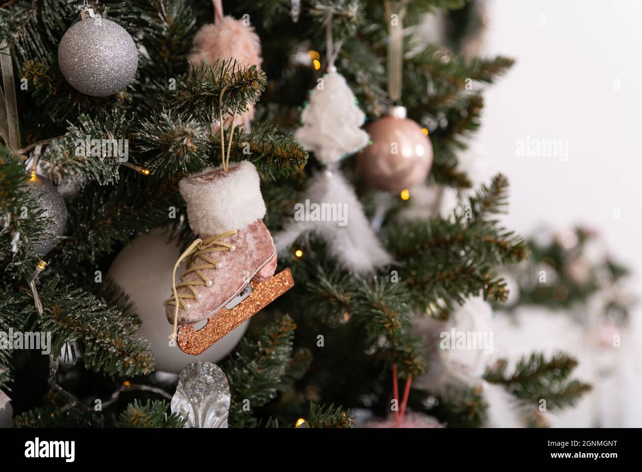 Árbol de Navidad decorado en colores rosa suave contra el fondo de la chimenea blanca clásica con decoraciones de Navidad. Detalles de las fiestas de Año Nuevo Foto de stock