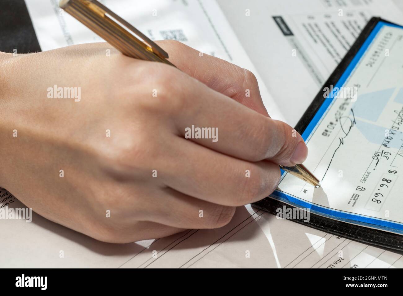 Mujer escribe cheques pagando facturas, Los Angeles, CA, Estados Unidos Foto de stock