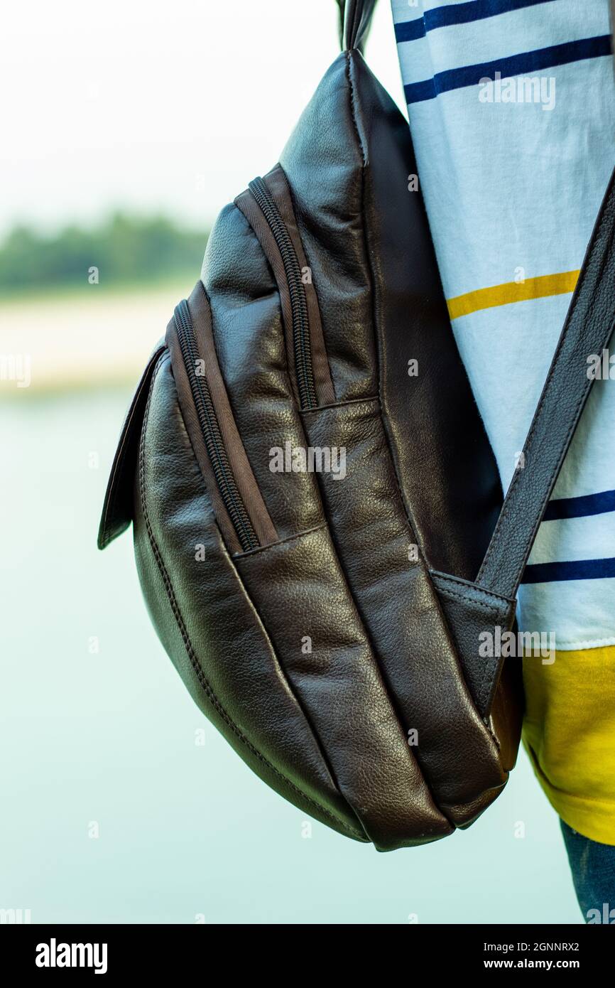 Una bolsa de cuero sólido o bolsa de transporte que se muestra en la espalda  del hombre y estar de pie en la orilla del río solo Fotografía de stock -  Alamy