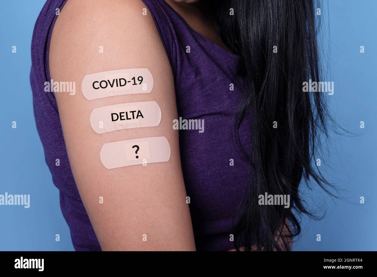 mujer que muestra muchos tiritas en el hombro con inscripción covid-19, delta, después de la vacuna coronavirus, nuevos sellos y concepto de mutación Foto de stock