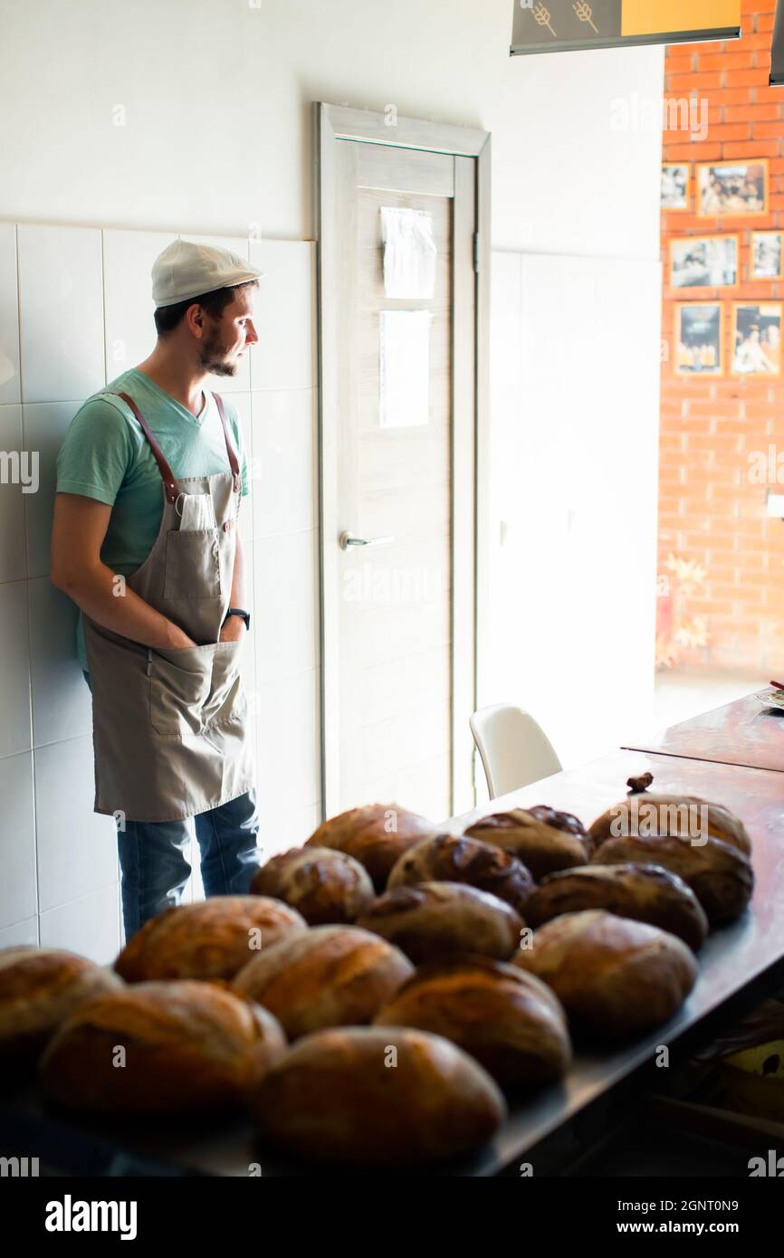 Joven panadero muestra su pan de masa de harina artesanal. Concepto de  éxito, final Fotografía de stock - Alamy