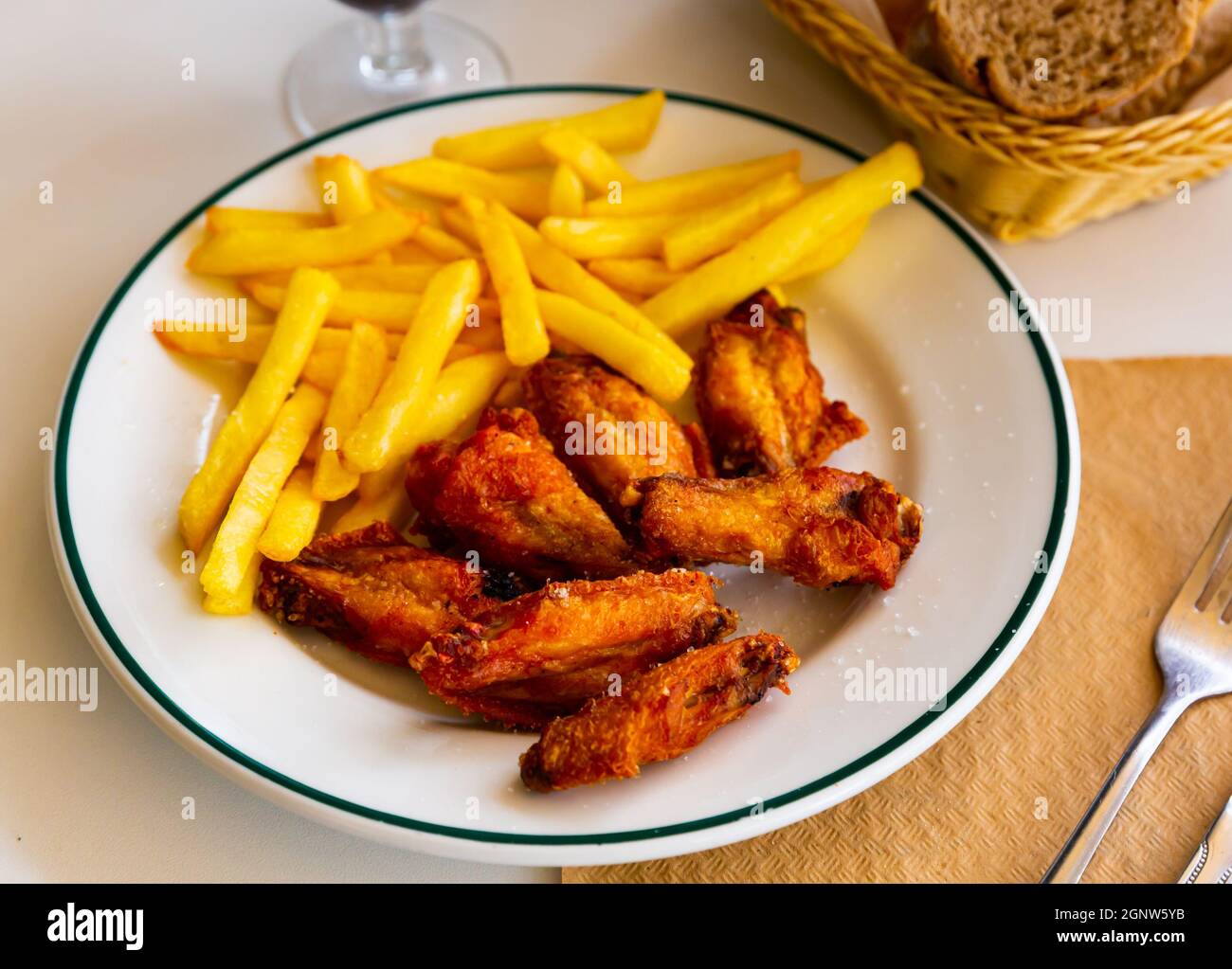Alitas de pollo fritas a la barbacoa con patatas al horno Fotografía de  stock - Alamy