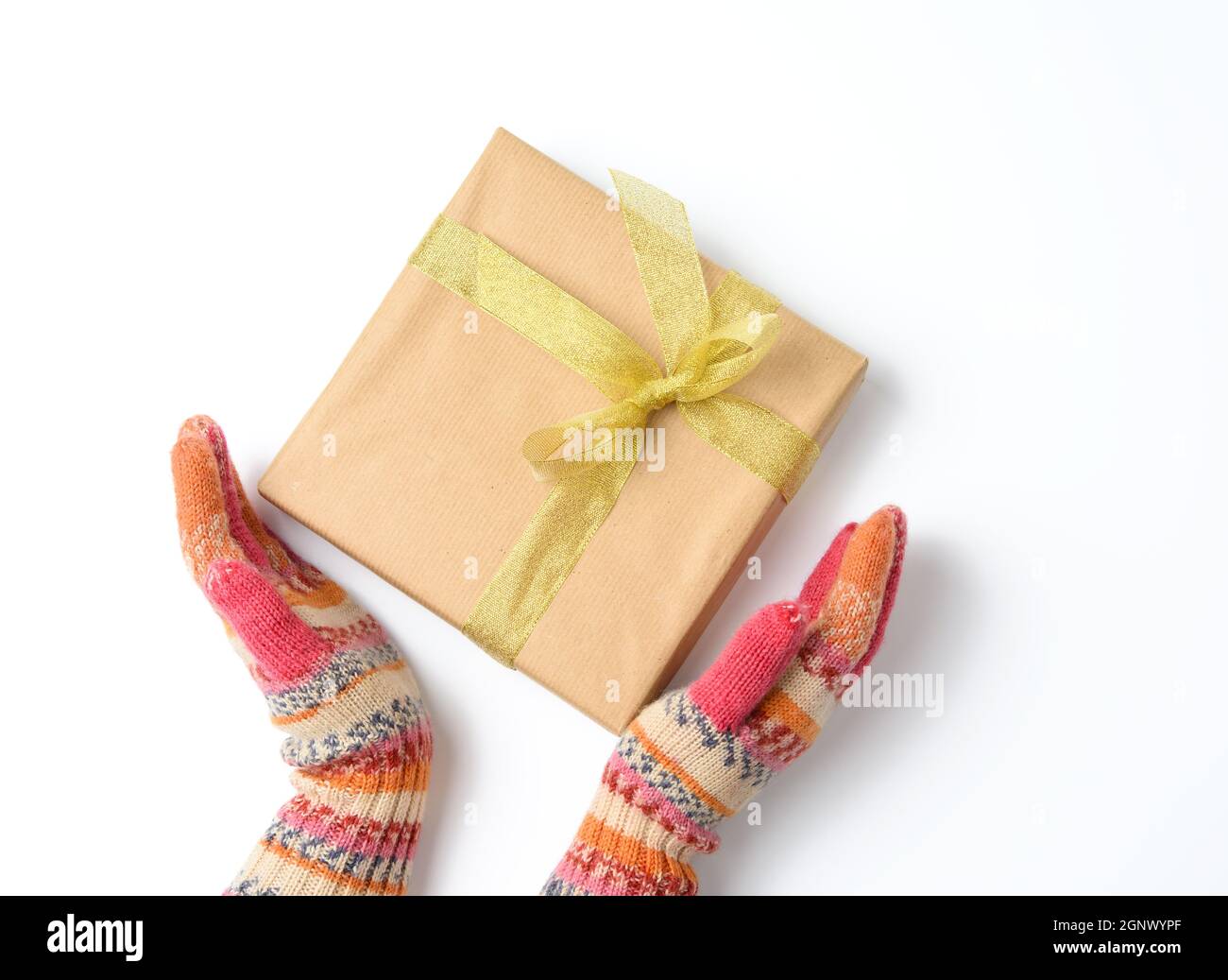 las manos femeninas en manoplas tejidas sostienen una caja envuelta en papel  marrón y atada con una cuerda sobre un fondo blanco, vista superior  Fotografía de stock - Alamy