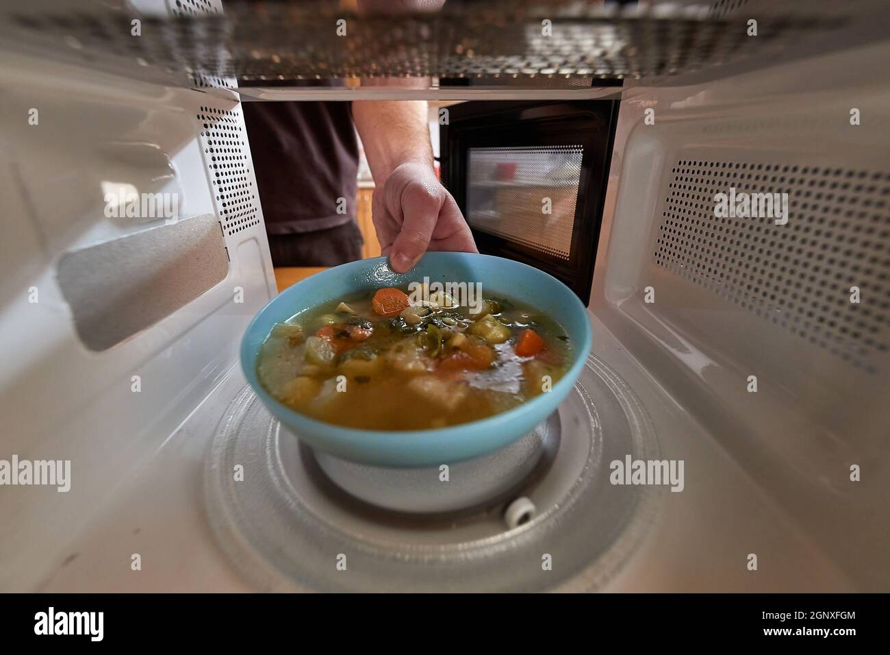 Calentar la comida en un microondas visto desde el interior de la espalda,  un tazón de sopa de verduras Fotografía de stock - Alamy