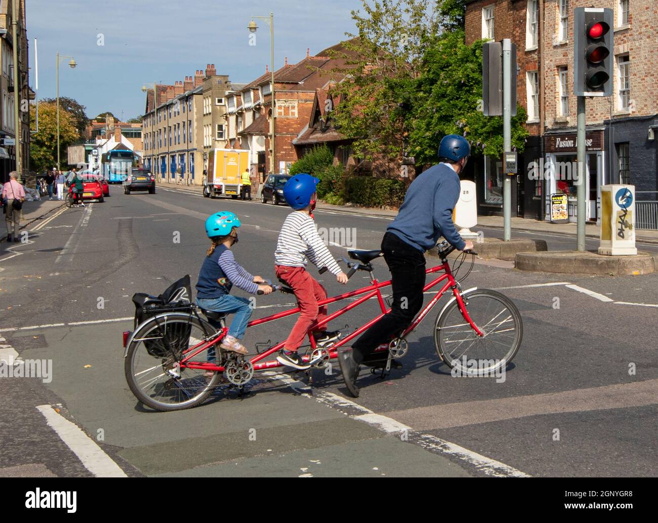 Hombre y dos niños en una bicicleta triple, o en tándem triplete, cruzando  St Giles St, Oxford Fotografía de stock - Alamy