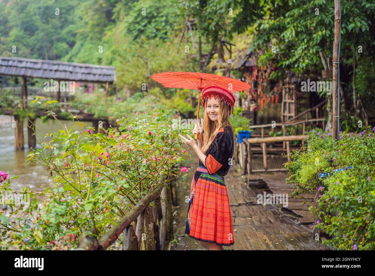 Una turista femenina vestida con el vestido tradicional de los habitantes de las montañas vietnamitas, el Hmong. Mujer en Sapa en la niebla, Noroeste Foto de stock