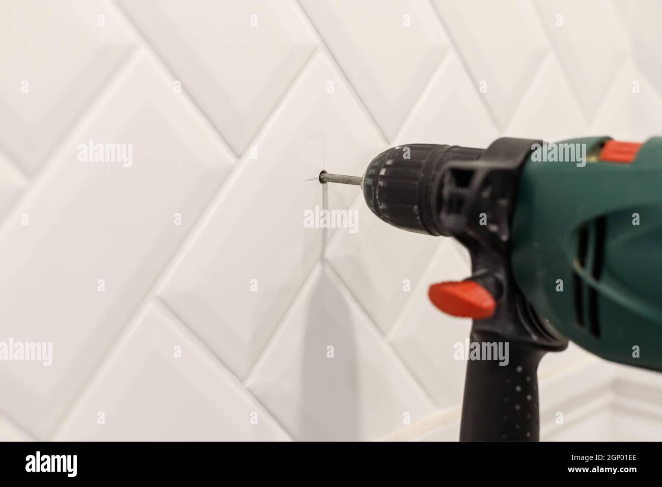 Agujero de perforación en azulejos de cerámica en la pared del baño. Vista  de primer plano Fotografía de stock - Alamy