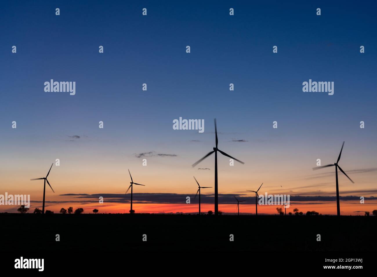 Producción de energía eléctrica con molinos de viento de manera sostenible con energías renovables al atardecer Foto de stock