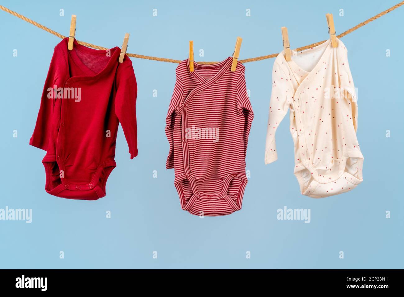 Ropa de niña fijada en una línea de ropa contra fondo azul Fotografía de  stock - Alamy