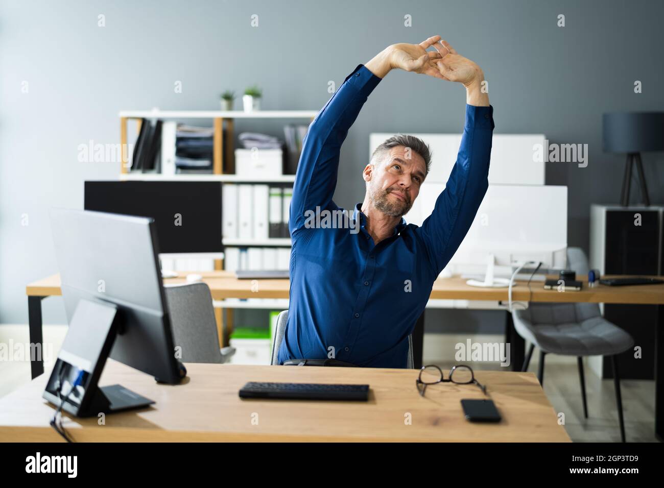 Ejercicios de estiramiento en el escritorio de la oficina en el trabajo.  Interrupción del estrés Fotografía de stock - Alamy