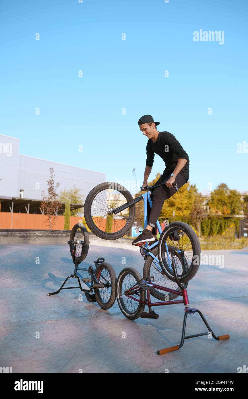 BMX bikers estilo de vida, entrenamiento en skatpark. Deportes extremos en  bicicleta, ejercicios peligrosos en bicicleta, paseos en la calle, ciclismo  de adolescentes en el parque de verano Fotografía de stock -