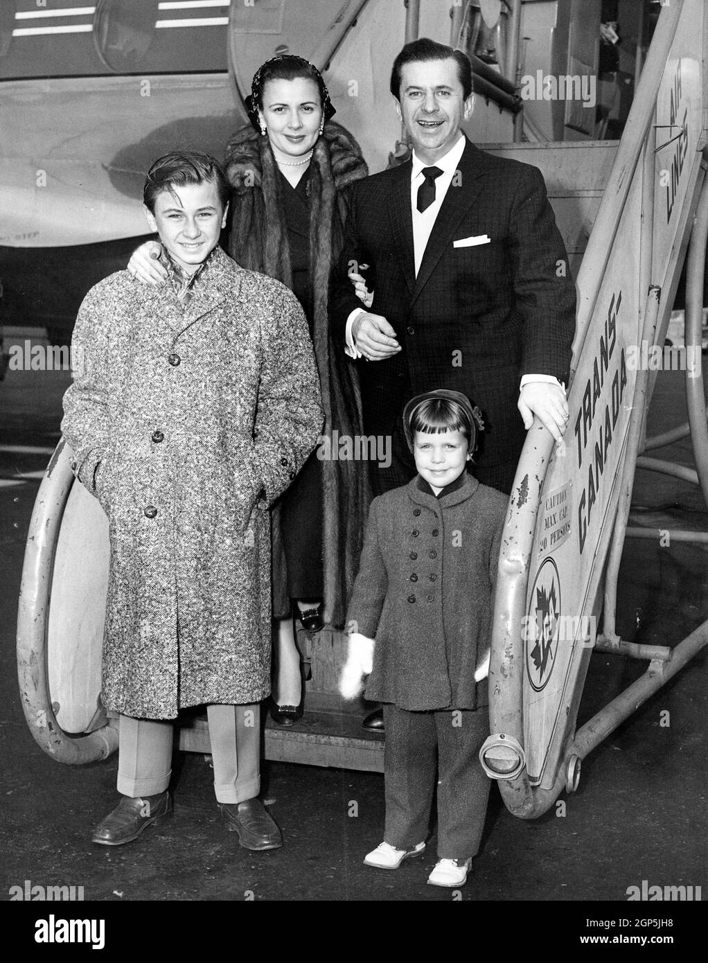 Morey Amsterdam (arriba a la derecha), su esposa Kay Patrick Amsterdam (arriba a la izquierda), su hijo Gregory Amsterdam (abajo a la izquierda) y su hija Cathy Amsterdam (abajo a la derecha), salen del Aeropuerto Internacional de Nueva York por Trans-Canada Air Lines, en dirección a Montreal, donde está haciendo una aparición personal, noviembre de 1955 Foto de stock