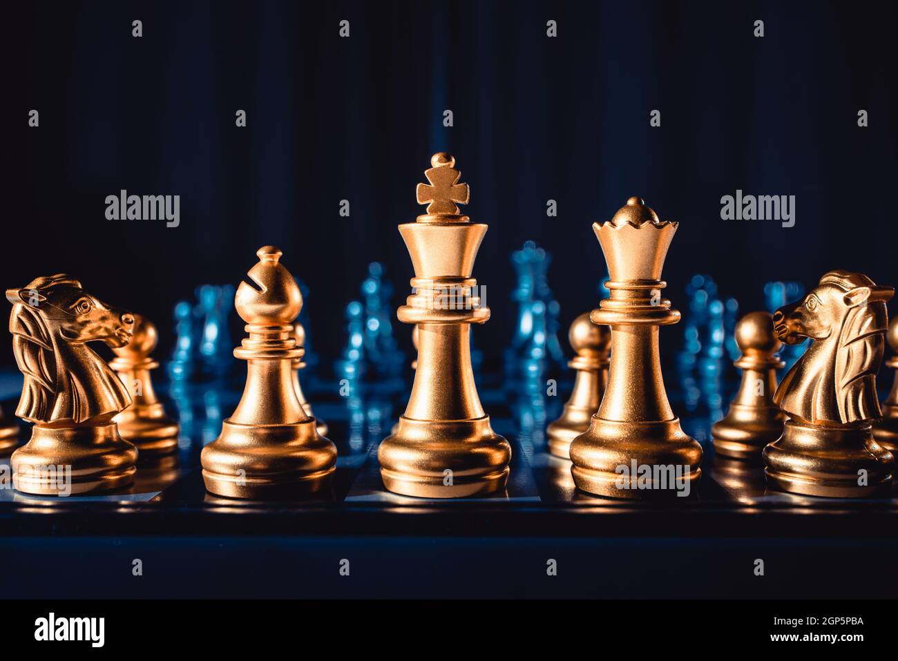Piezas de ajedrez de color dorado se encuentran en el primer plano del  tablero. Juego de mesa Fotografía de stock - Alamy