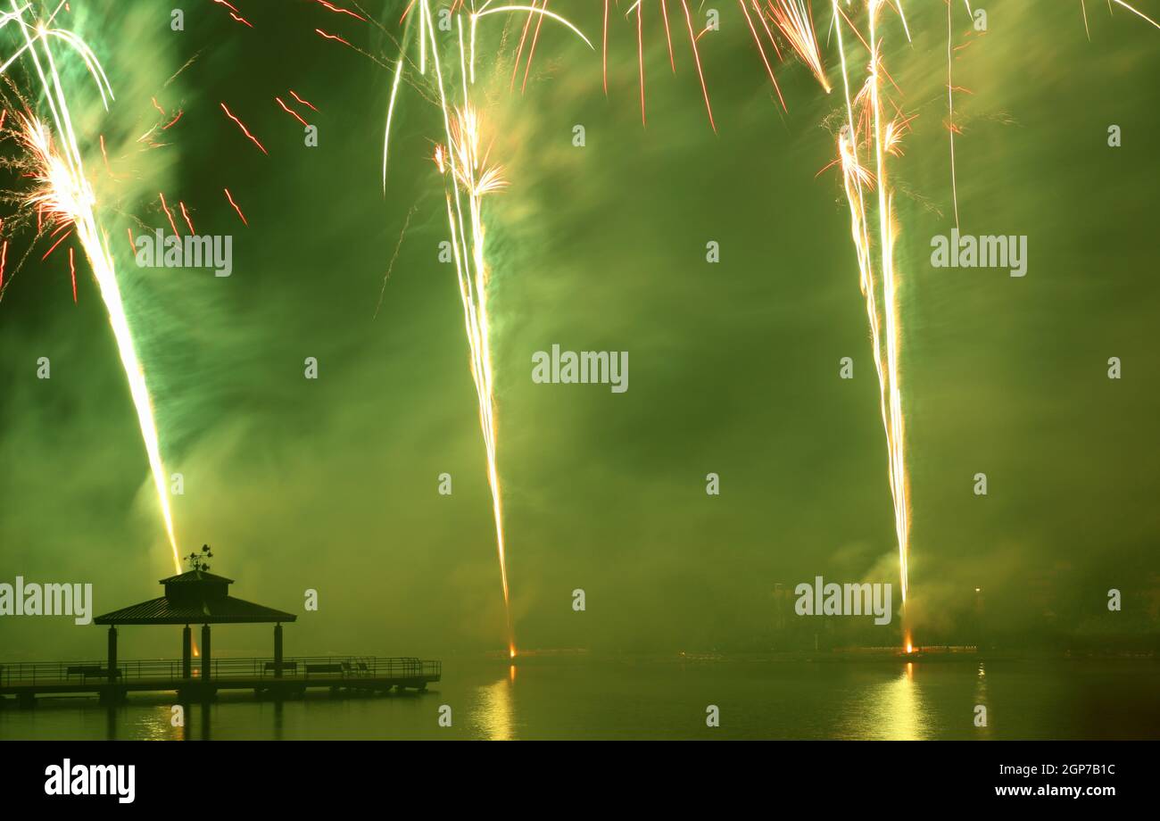 Fuegos artificiales en Delco Park. El muelle de pesca y la silueta del pabellón en primer plano muestran fuegos artificiales. Delco Park, Kettering, Dayton, Ohio, Estados Unidos. Foto de stock