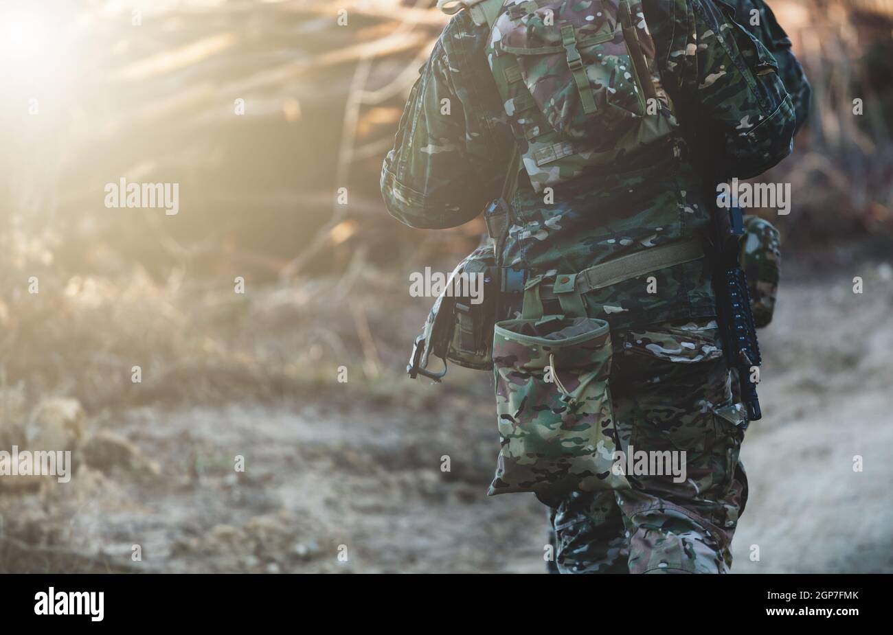un militar con un uniforme de camuflaje y guantes tácticos