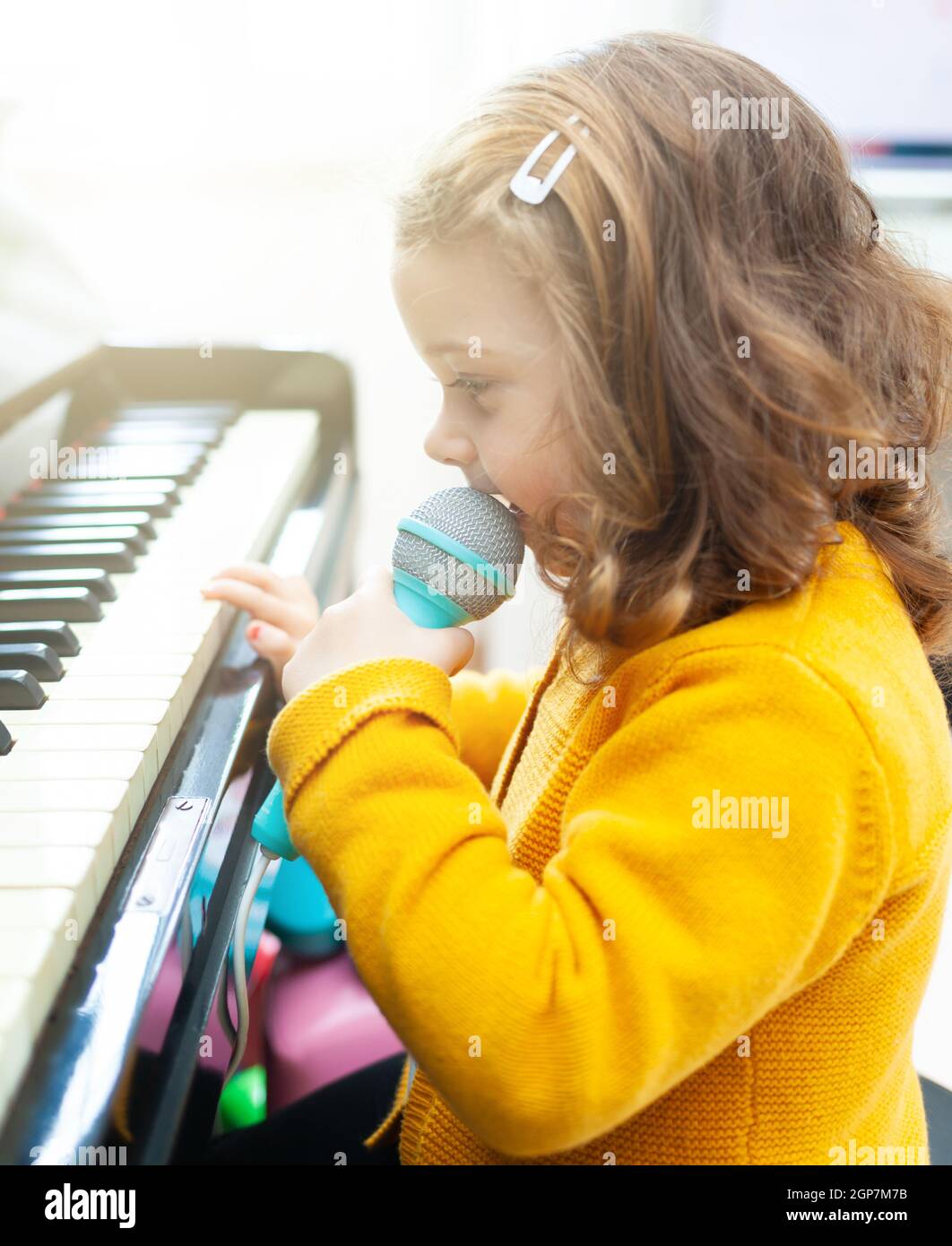 Niña niño toca el piano y canta con el micrófono de juguete Fotografía de  stock - Alamy