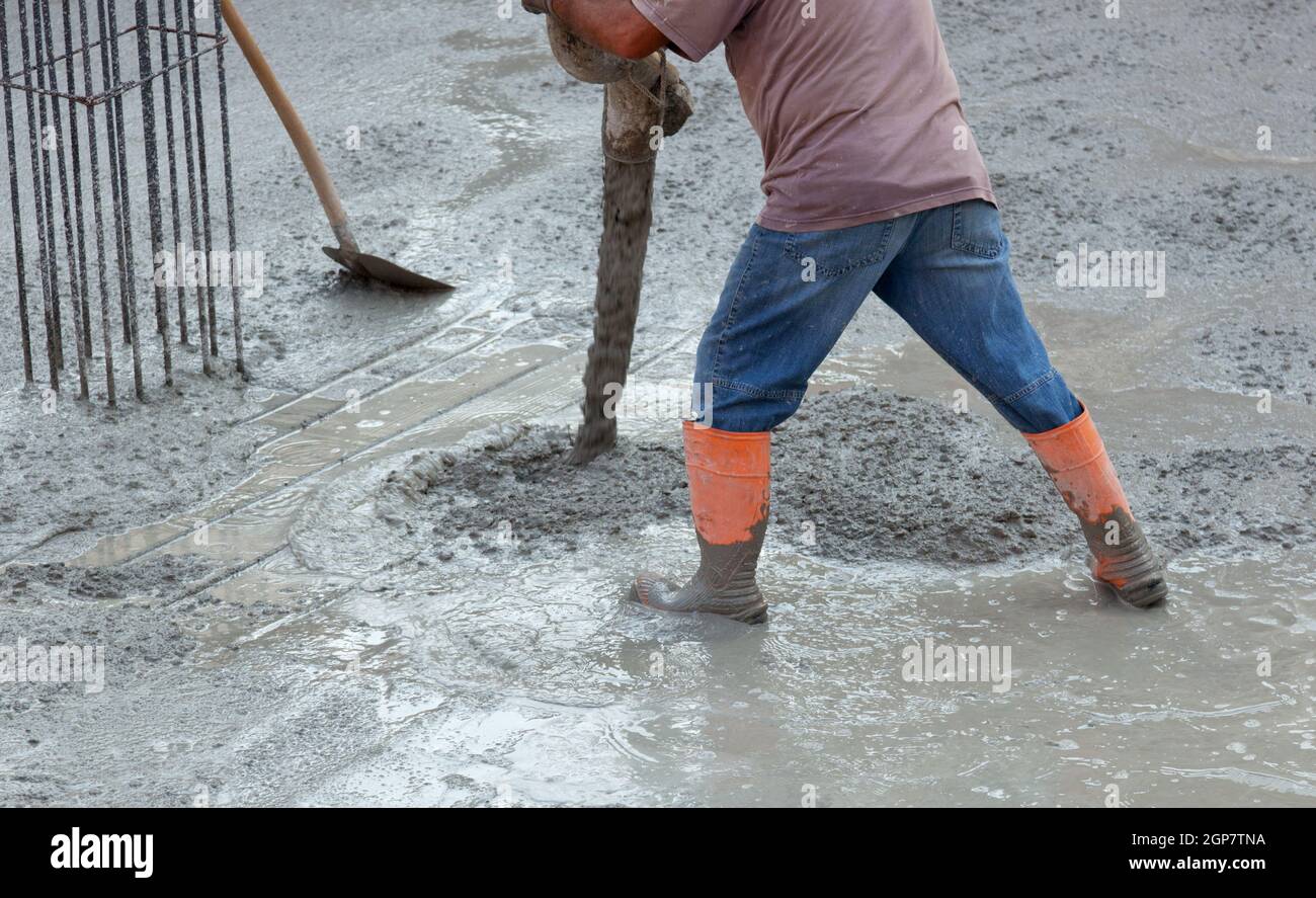 Builder trabajador con tubo de camión bomba de concreto montada echar cemento en encofrado de refuerzo Foto de stock