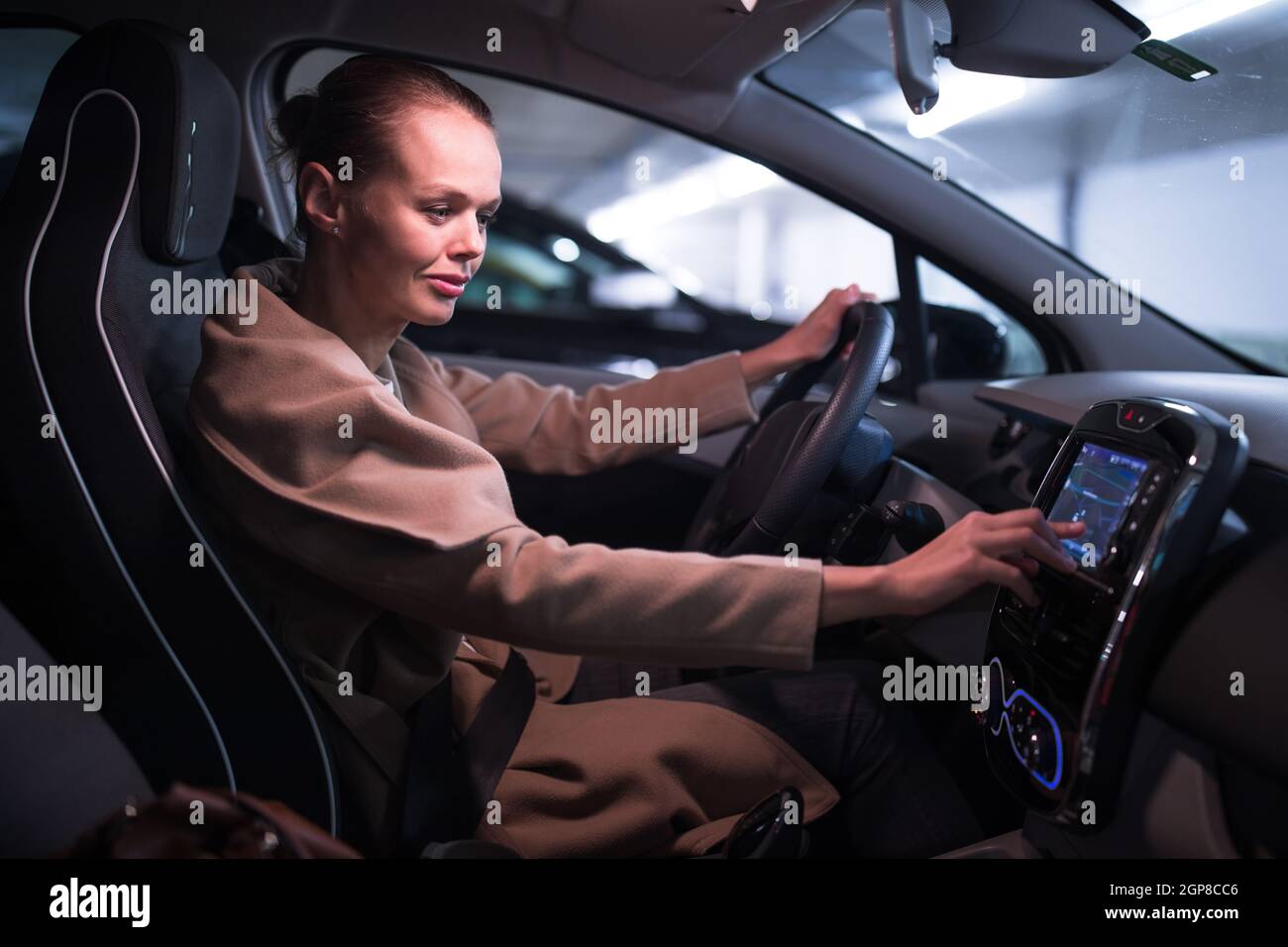 Estacionamiento subterráneo/garaje (DOF poco profundo; imagen en tonos de color) - mujer joven conduciendo su coche en el estacionamiento subterráneo Foto de stock