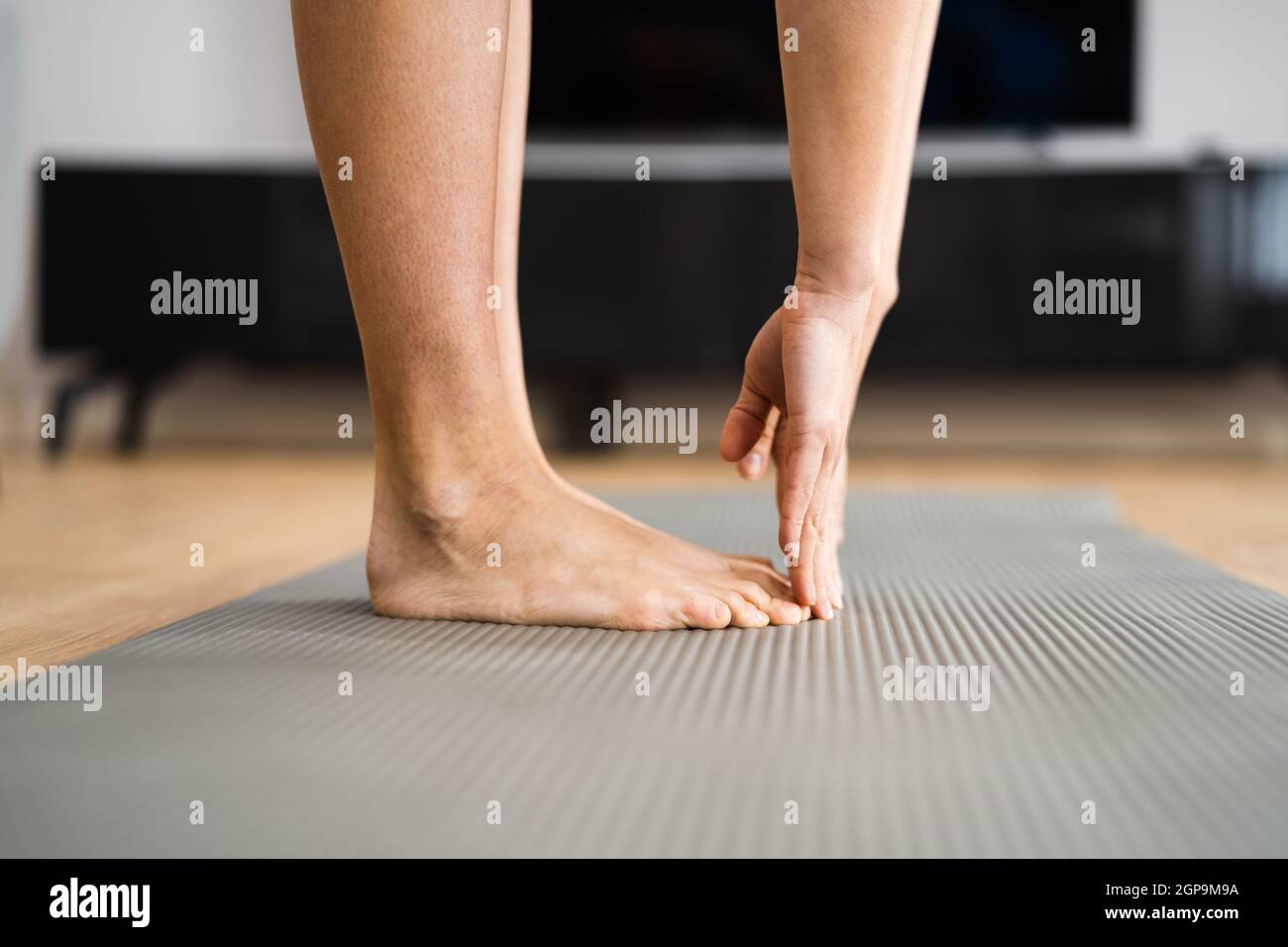 Mujer haciendo la prueba de estiramiento de la aptitud. Tendones de la corva apretados Foto de stock
