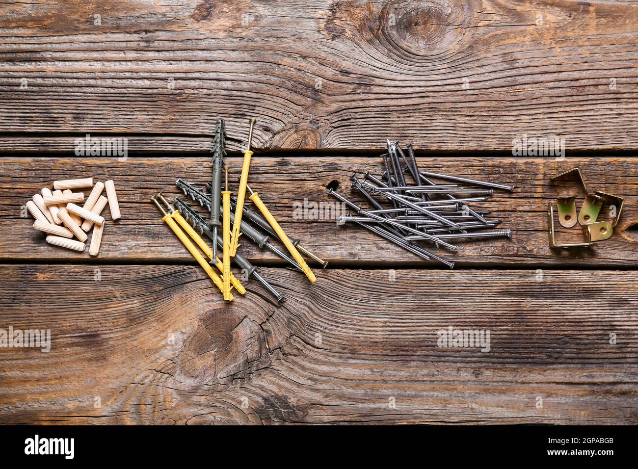 Montones de espigas, tornillos de madera, clavos y esquinas de muebles  sobre fondo de madera Fotografía de stock - Alamy