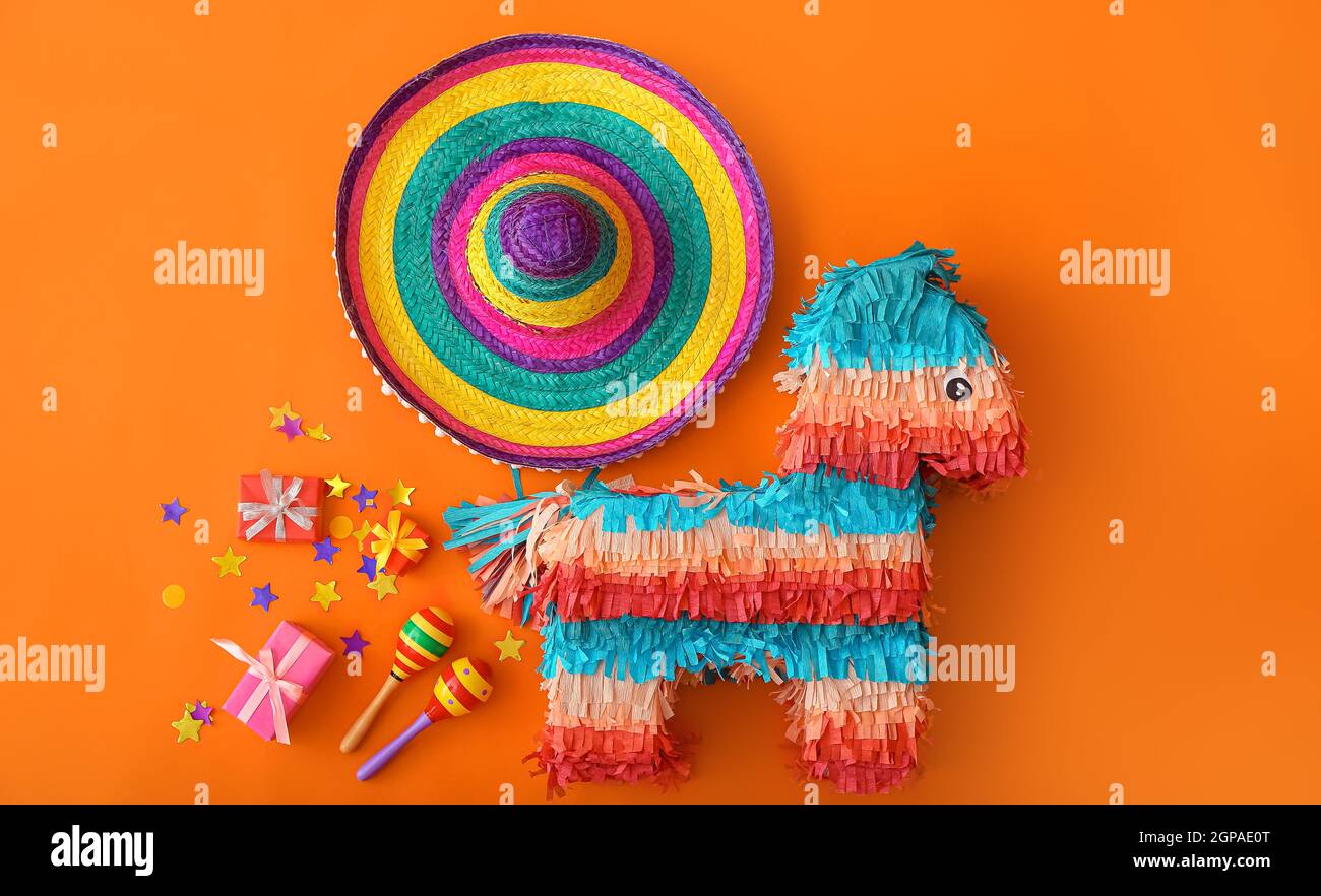 Pinata mexicana con sombrero sombrero, maracas y regalos sobre fondo de  color Fotografía de stock - Alamy