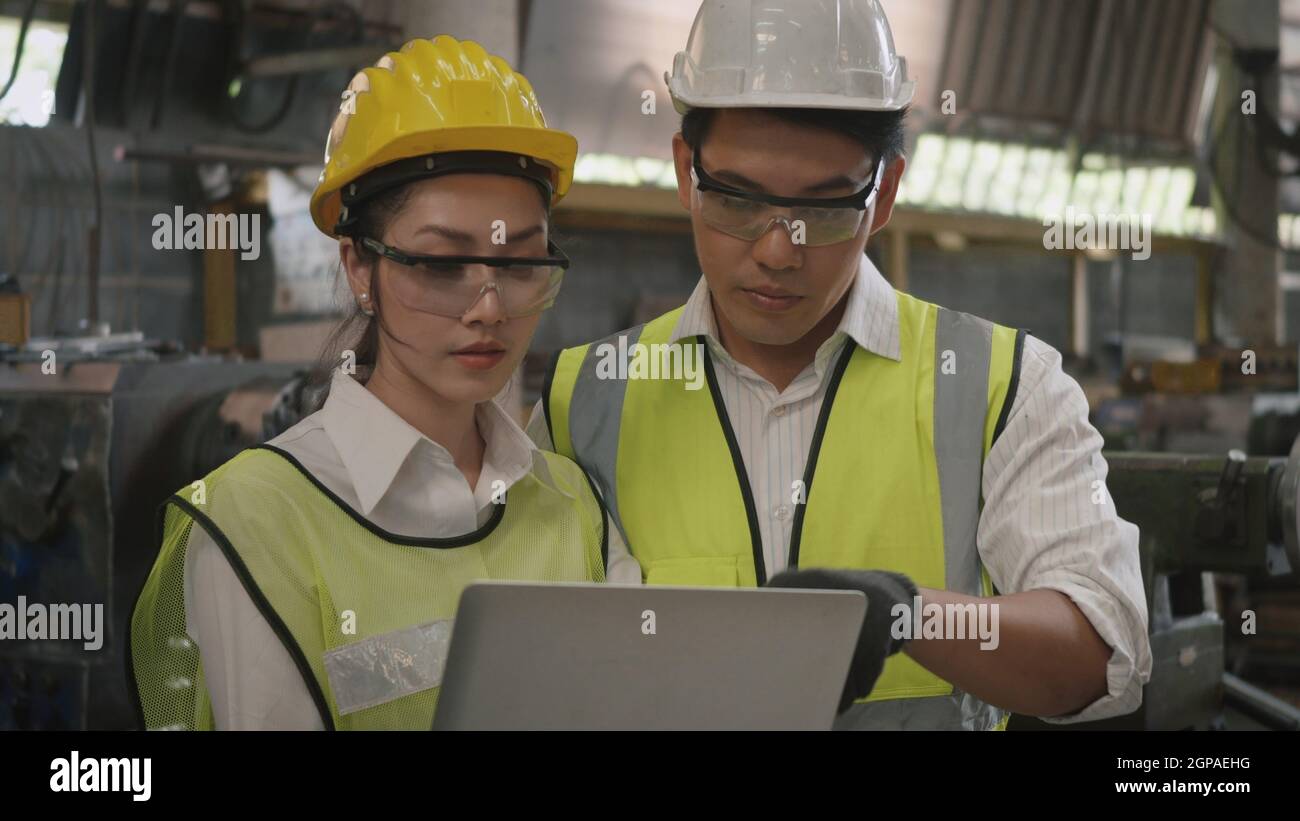 Mujer ingeniero mecánico profesional asiática y hombre de la operación con  uniforme casco y gafas de seguridad trabajando en taller metal torno  industrial m Fotografía de stock - Alamy