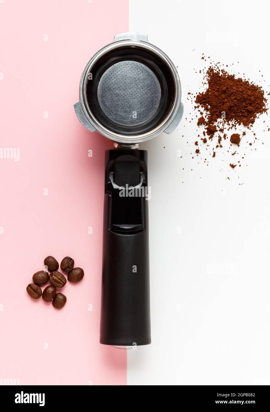 Soporte de filtro para máquina espresso, café molido y granos de café sobre  fondo rosa y blanco Fotografía de stock - Alamy