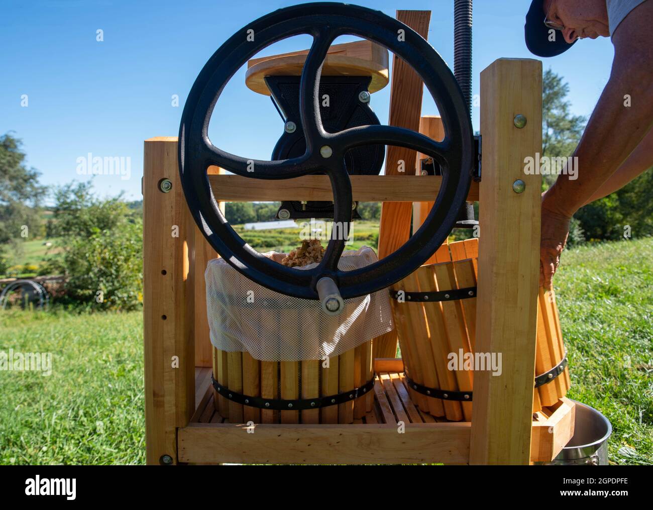 Un hombre haciendo sidra de manzana con prensa tradicional de fruta con volante Foto de stock