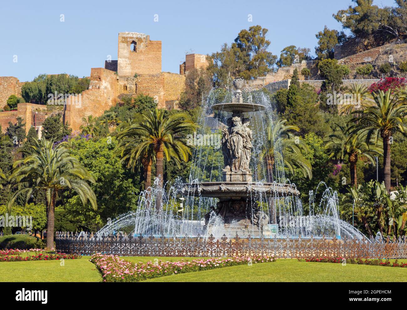 Fuente de las Tres Gracias también conocida como las Tres Ninfas en la Plaza del General Torrijos con la Alcazaba morisca, o fortaleza, detrás. Málaga, Cos Foto de stock