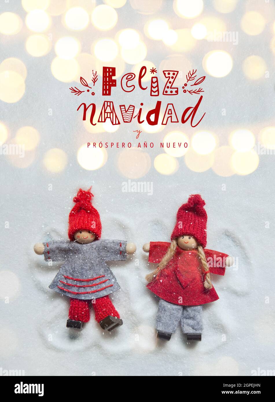 Tarjeta de felicitación de Navidad con pequeños adornos de muñecas de  Navidad que hacen ángeles en la nieve con luces bokeh. Feliz Navidad letras  graciosas de la escritura a mano Fotografía de