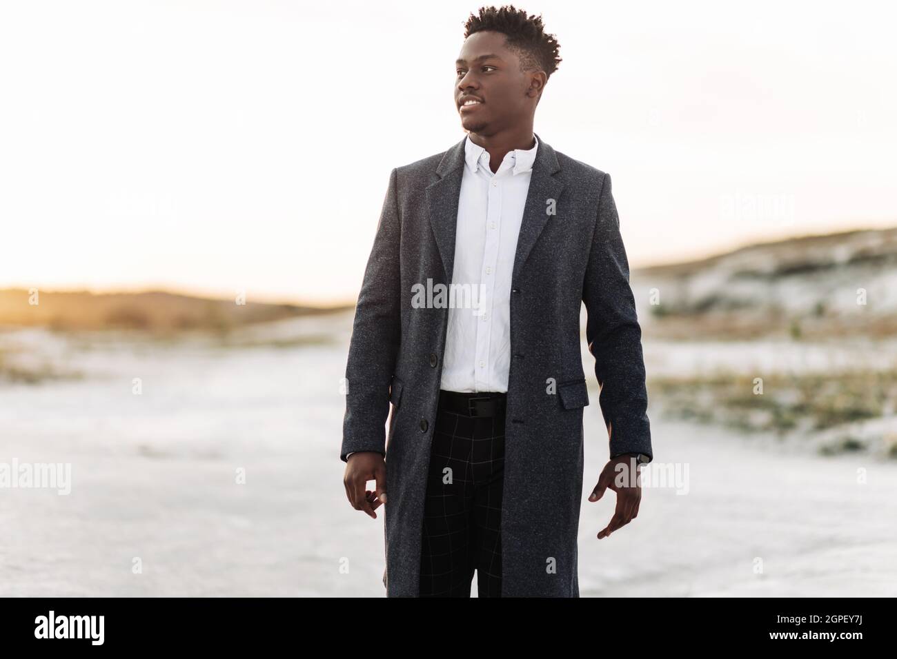 Elegante hombre negro con camisa blanca clásica, pantalones y abrigo,  posando al aire libre al atardecer, hombre de éxito, concepto de moda, moda para  hombre, clase Fotografía de stock - Alamy