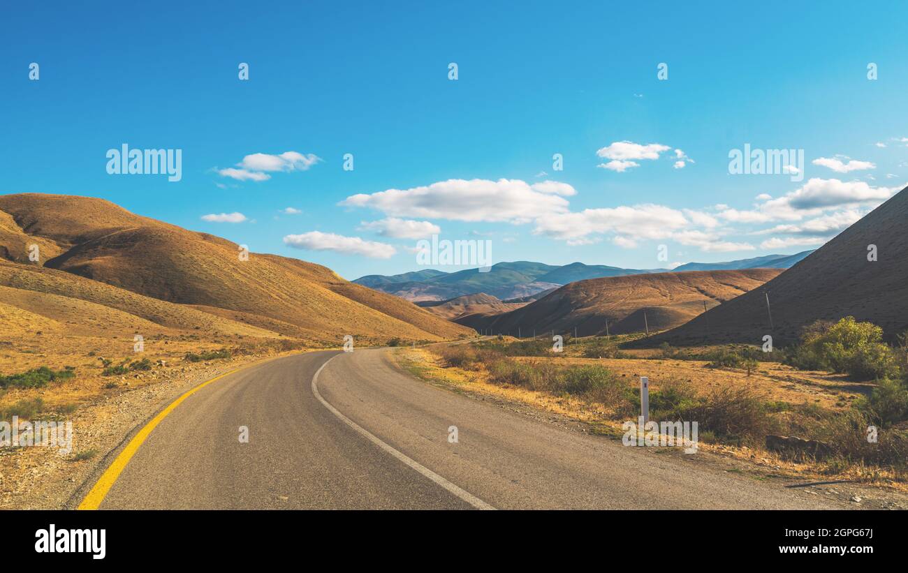 Asfalto camino en terreno montañoso Foto de stock