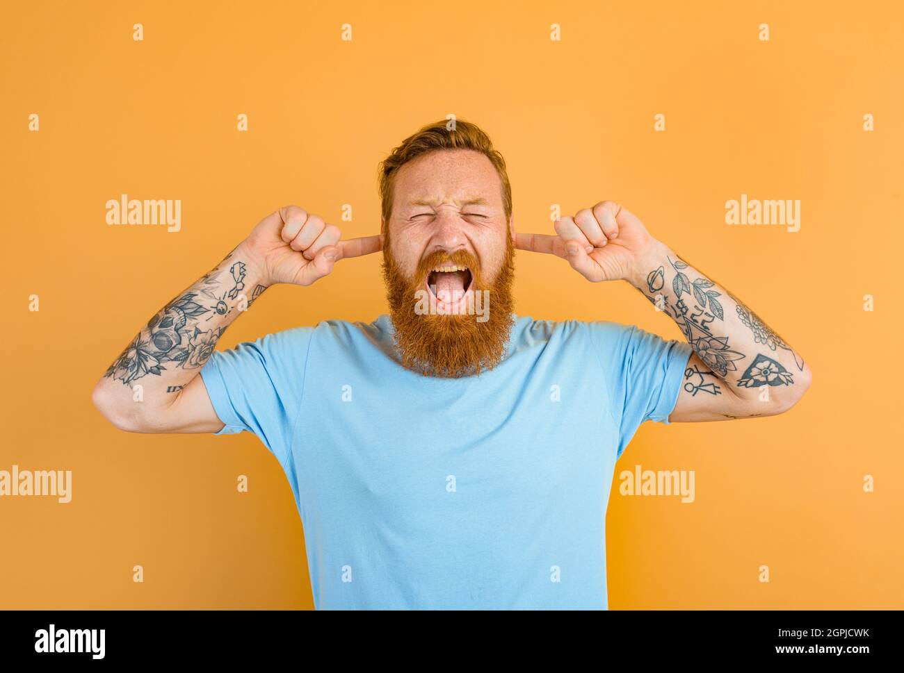 El hombre estresado con barba y tatuaje no quiere oír Foto de stock