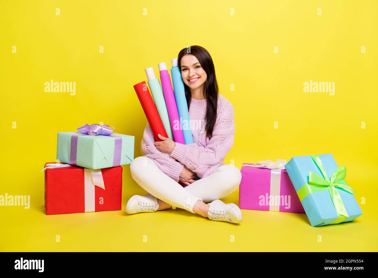 Foto de cuerpo entero de la dama millennial hold pack rollos regalo ropa  jersey pantalones aislados sobre fondo amarillo Fotografía de stock - Alamy