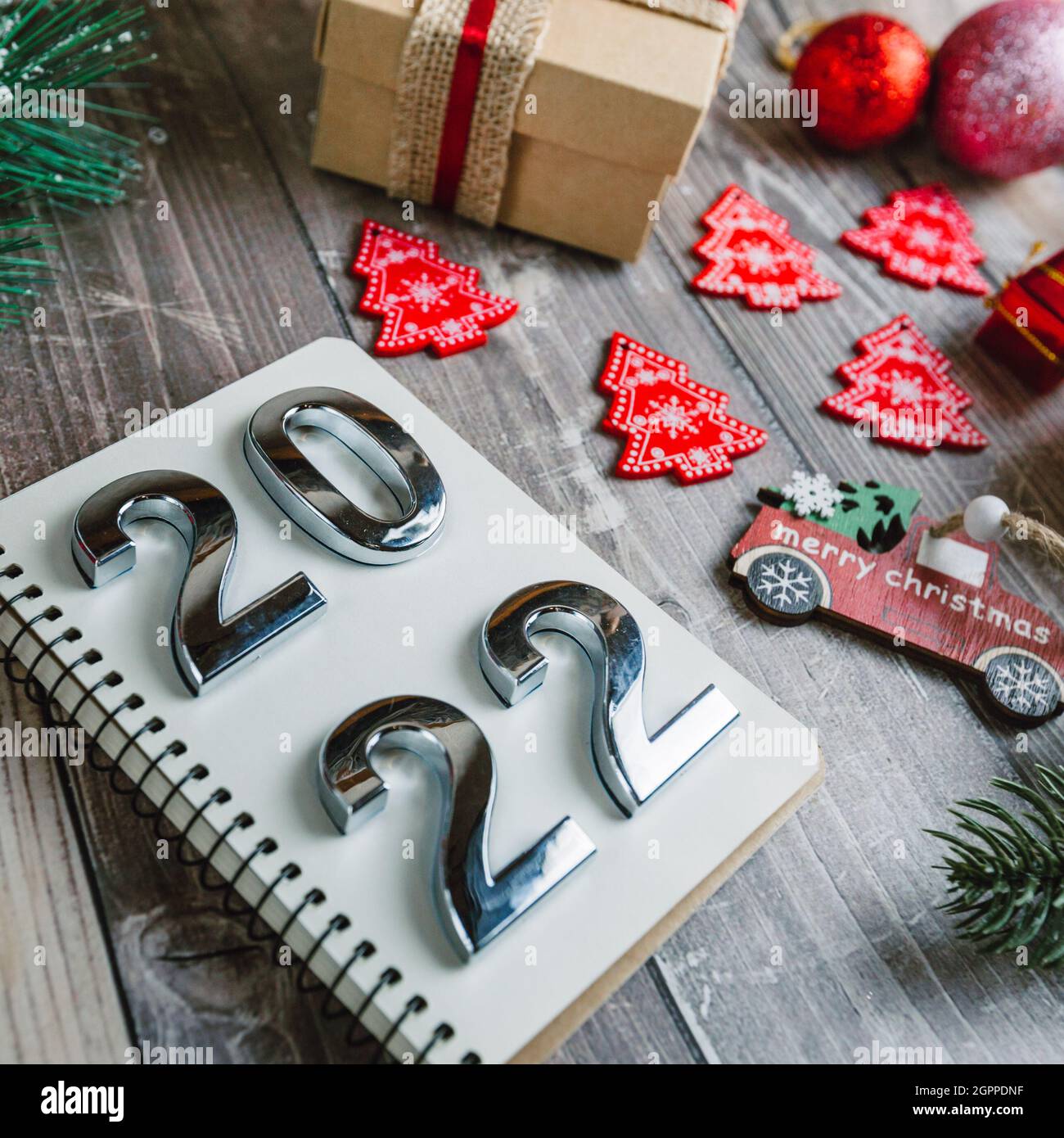 Números 2022 en un bloc de notas espiral sobre un fondo de madera con decoraciones de Navidad Foto de stock