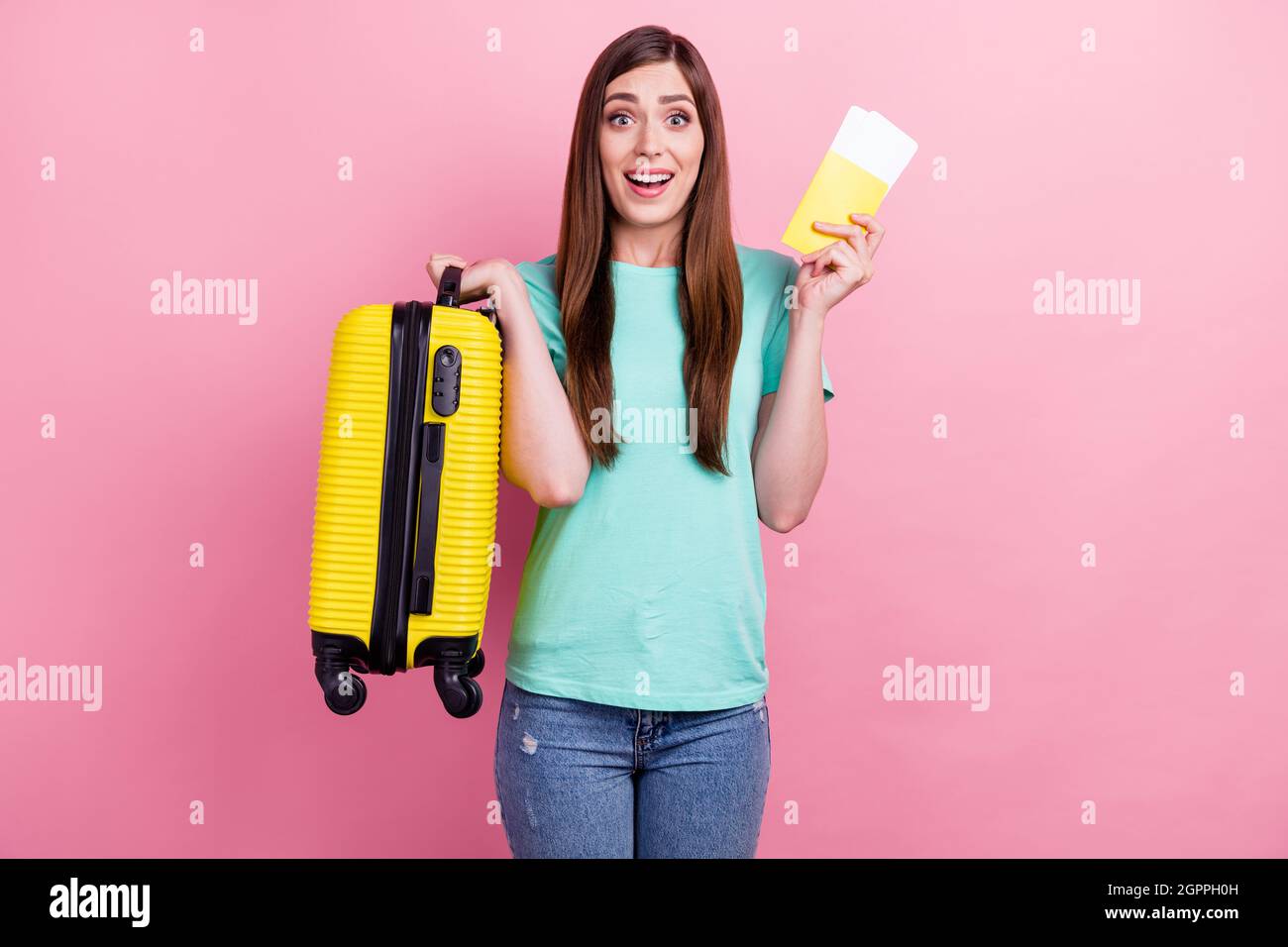 Foto de la joven dama impresionada ropa de camiseta de teal sonriente  sosteniendo boletos de maleta aislados color rosa fondo Fotografía de stock  - Alamy
