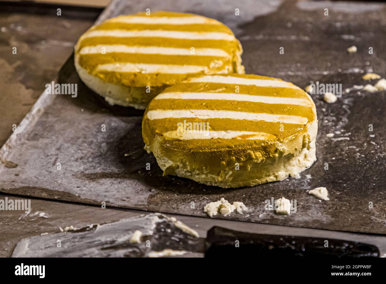 Producción de queso ahumado único en la lechería y cervecería Gundestrup (Gundestrup Mejeri og Bryghus). Después de 20 segundos en el denso humo de la paja, las ruedas de queso están rayadas Gundestrup, Svendborg, Dinamarca Foto de stock